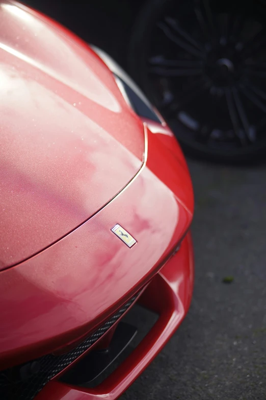 close up of front end of red car with shiny hood