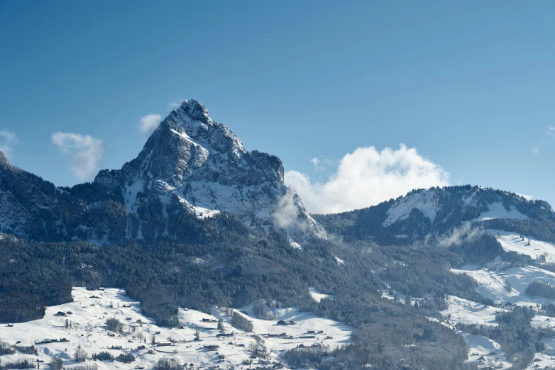 a view of the mountains with snow and clouds on them