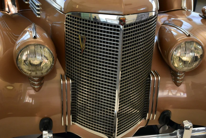 an old fashion brown car with chrome grills