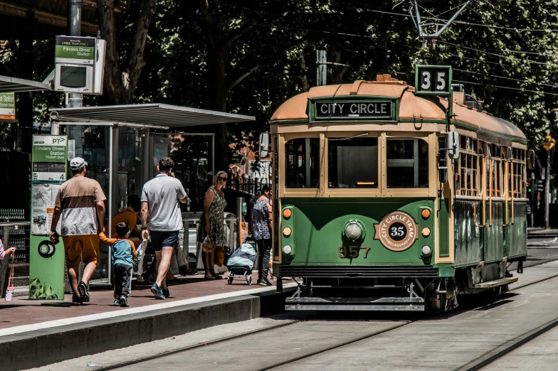 an older fashioned trolly car is traveling down the street