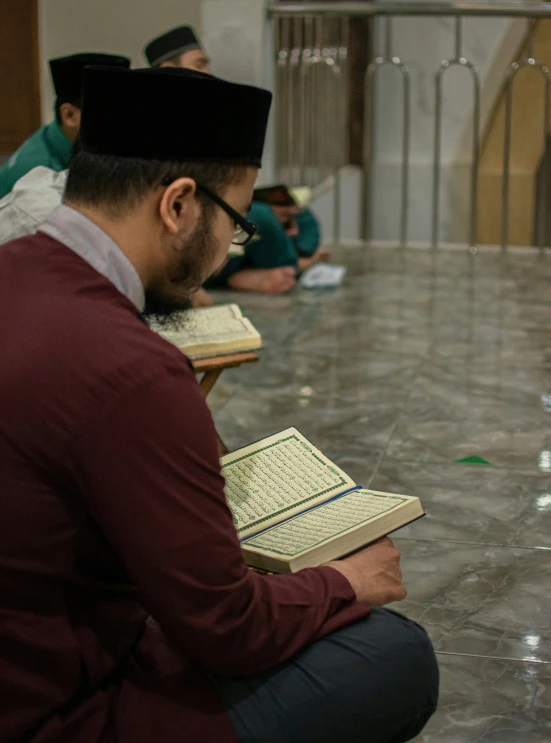 a man sitting with his legs crossed while reading a book