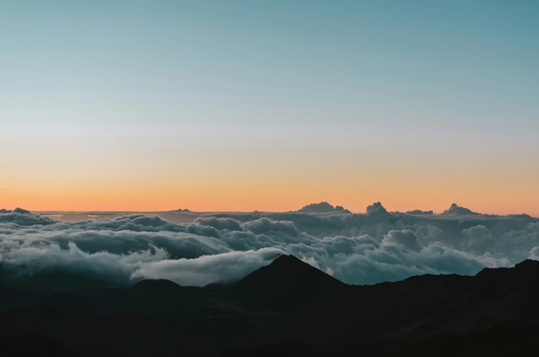 the sky is shown above the clouds as the sun sets