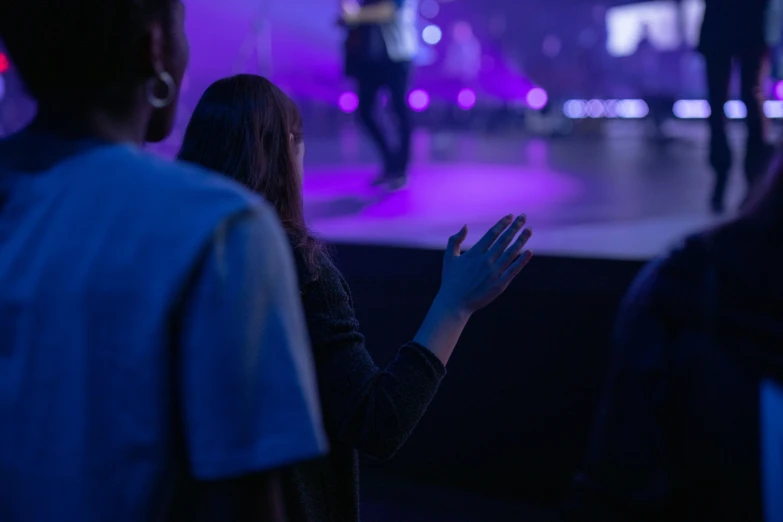 two people talking and some people clapping in the background