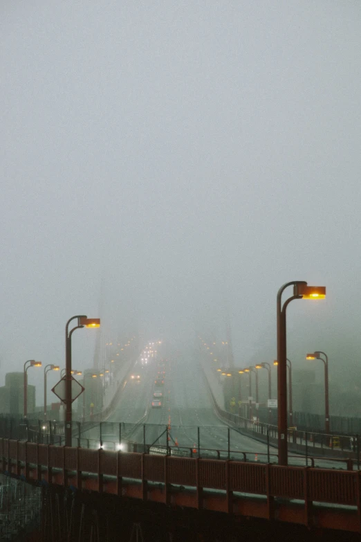 a foggy city street with multiple traffic lights