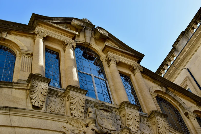 a very pretty building with big windows and a clock on it's front