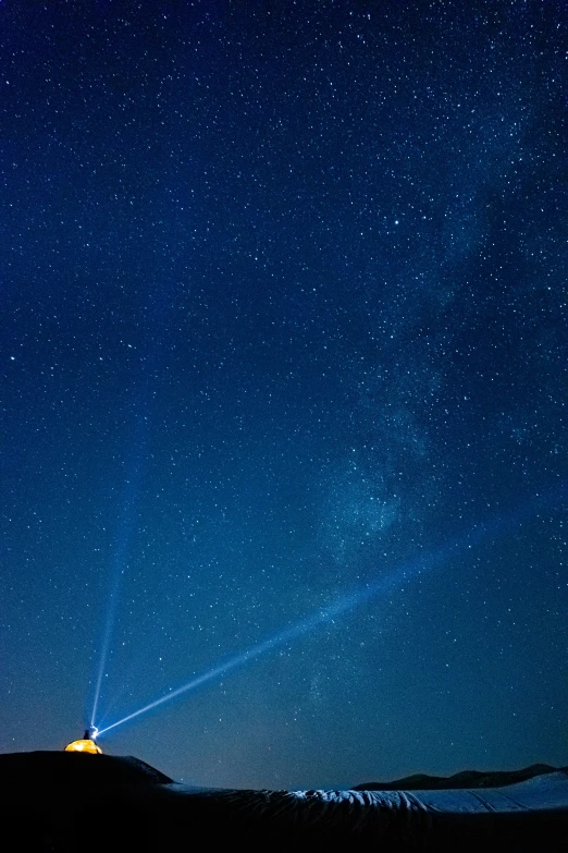 a dark sky full of stars above a distant building