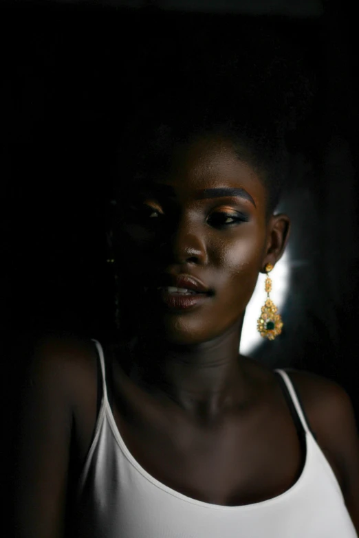 a black woman with bright makeup in a dark background