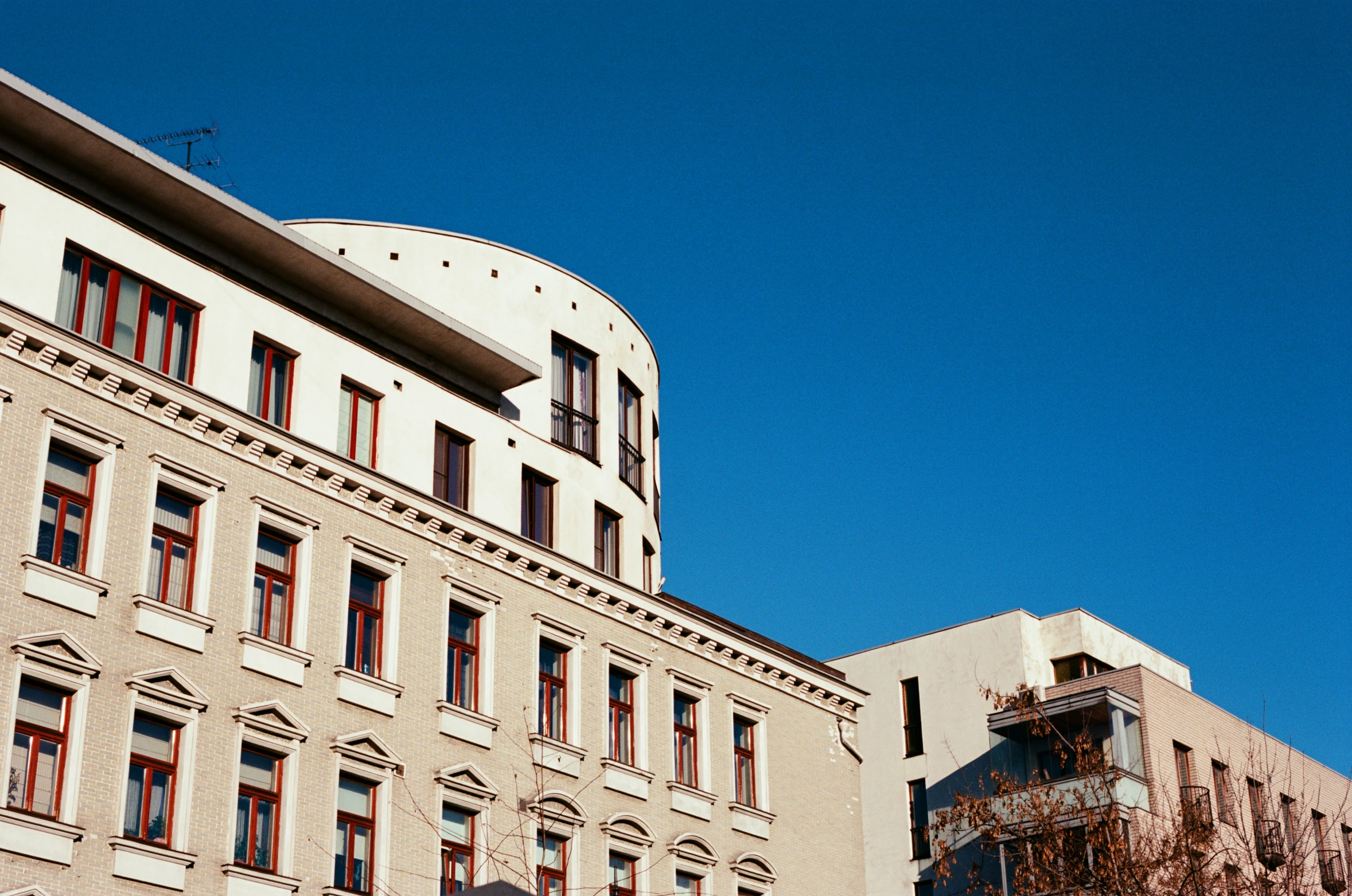 an older building stands with red windows and brown balconies