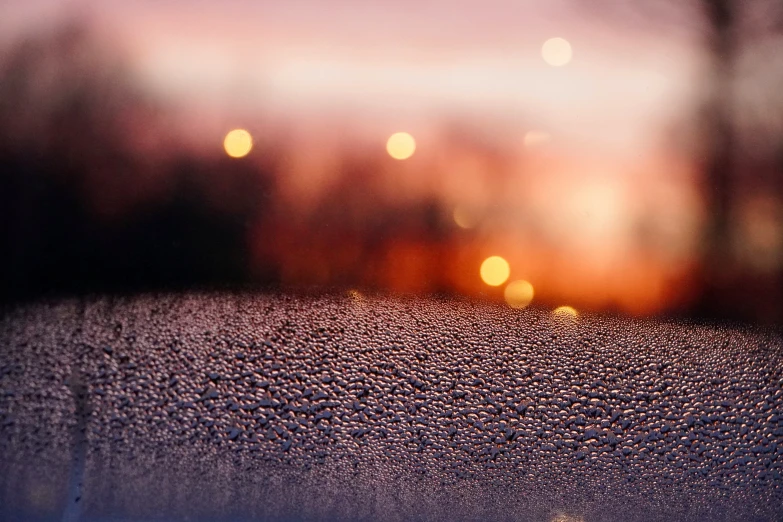 a frosted window has blurred lights in the background