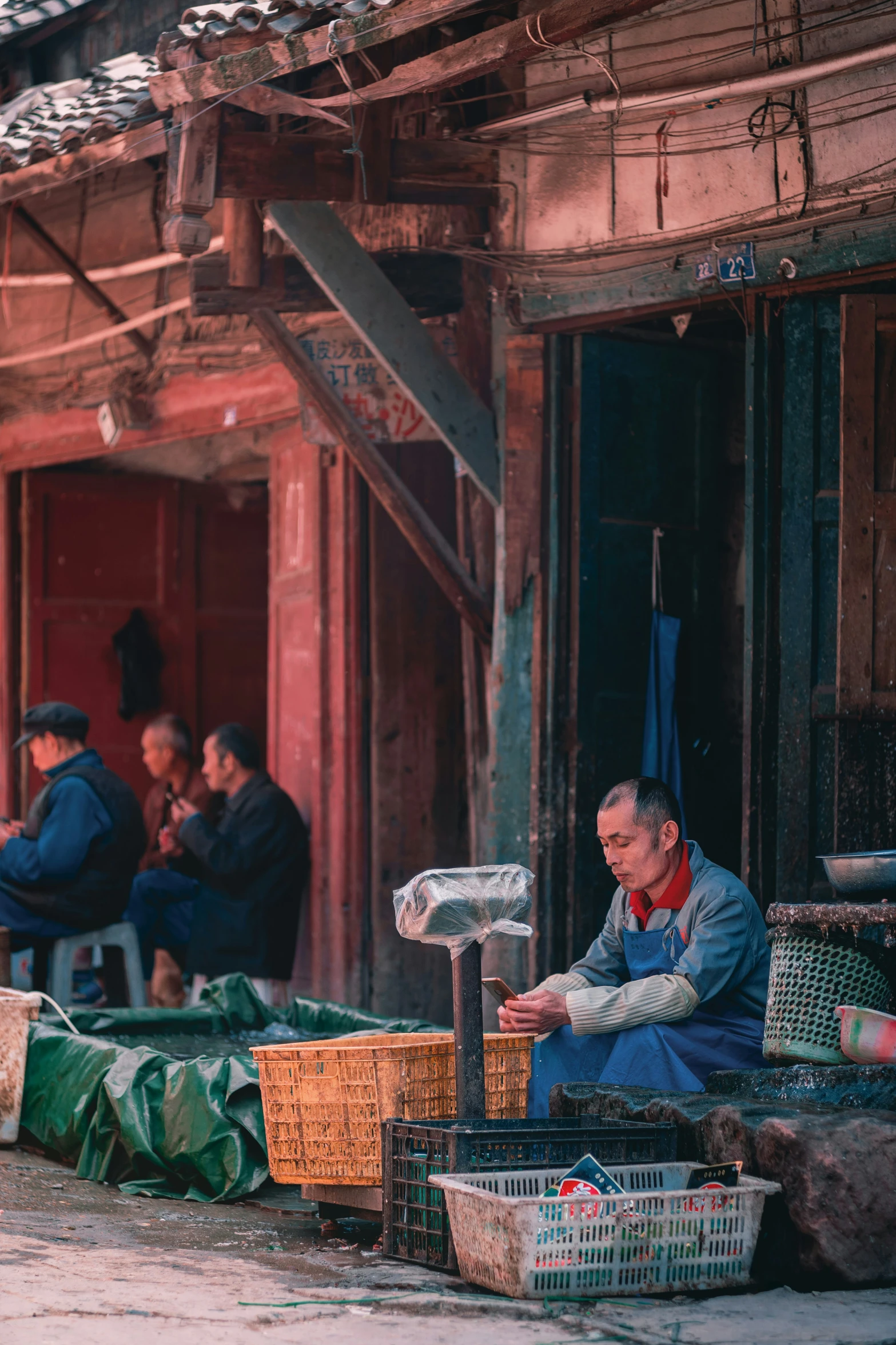 a man sitting in front of a wooden building