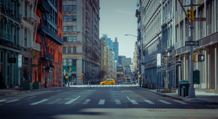 a yellow car that is driving down a street