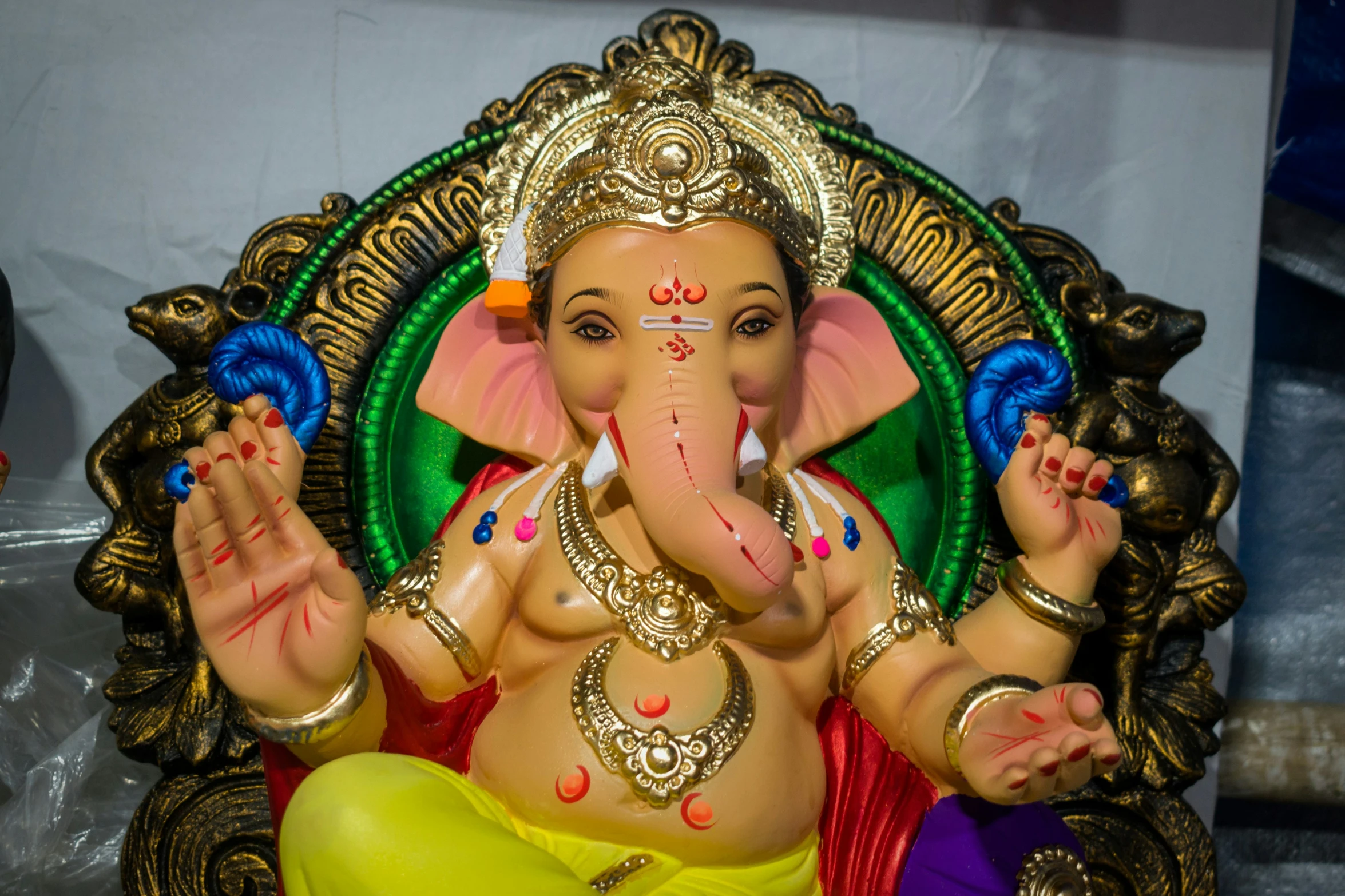 a statue of a hindu man sitting on a golden elephant