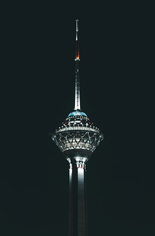 a very tall building in the dark with a sky line