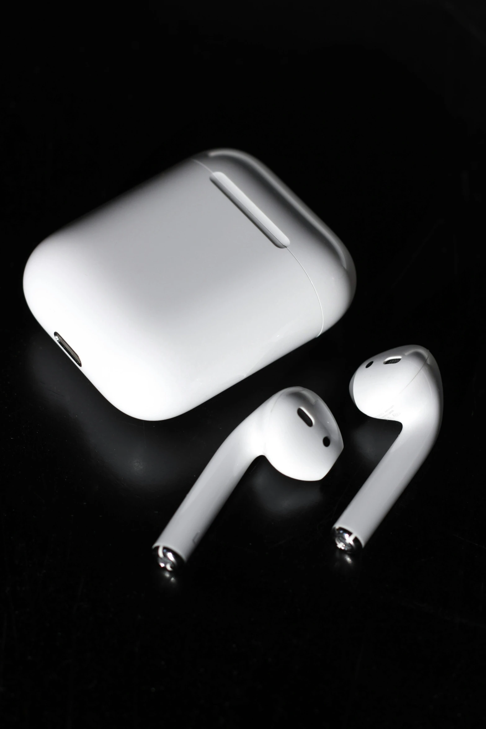 two white earbuds next to an electronic device