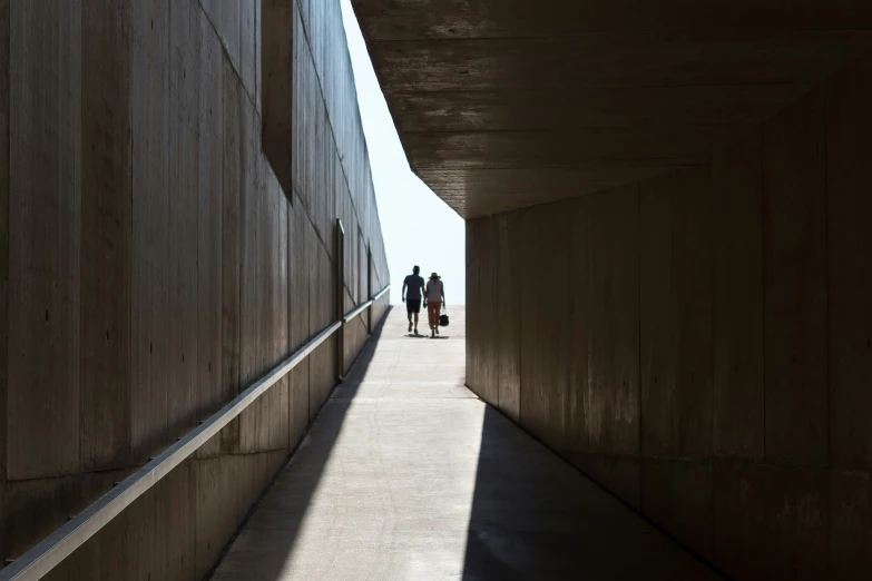 the couple are walking between concrete walls