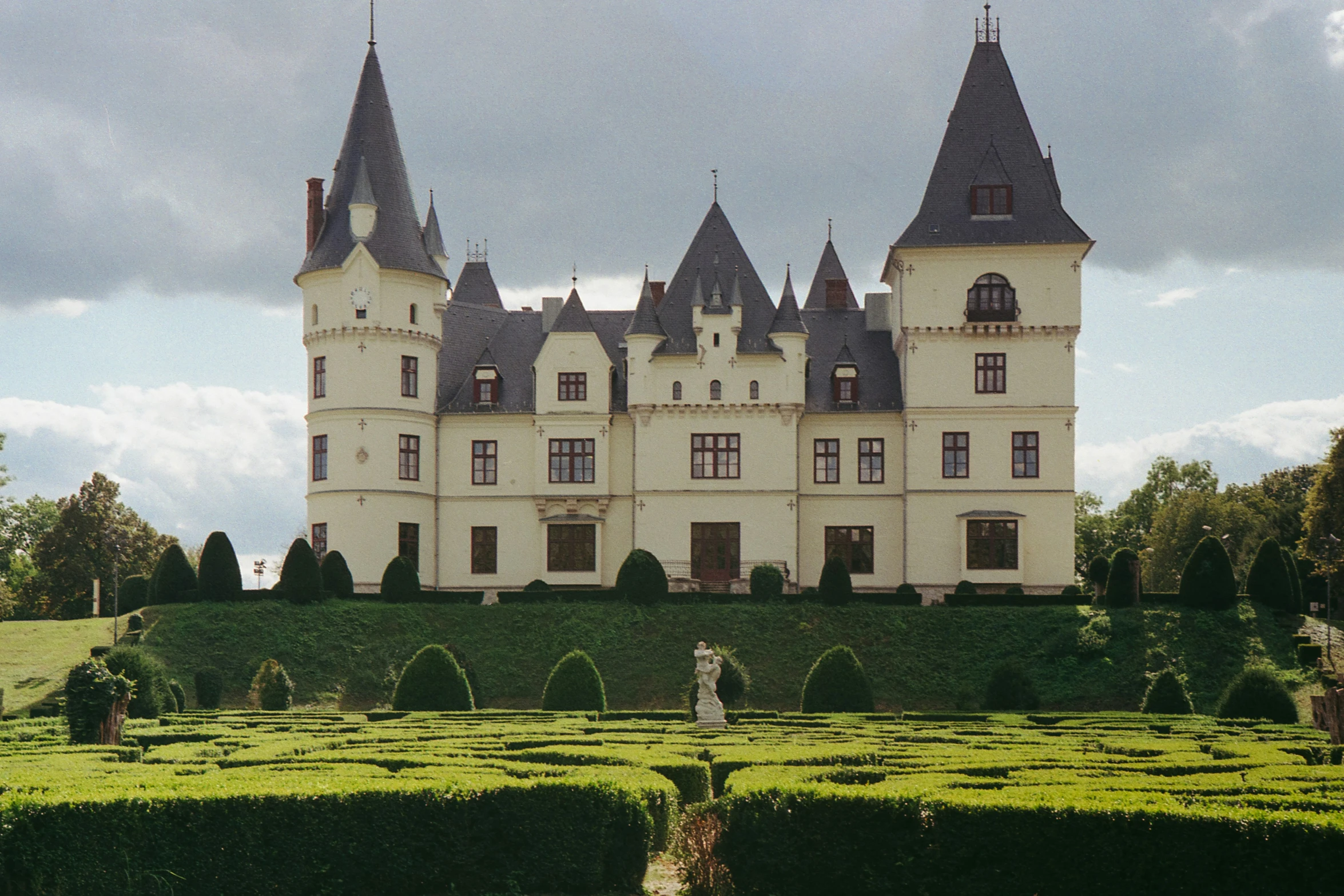 a very big pretty house with some hedges