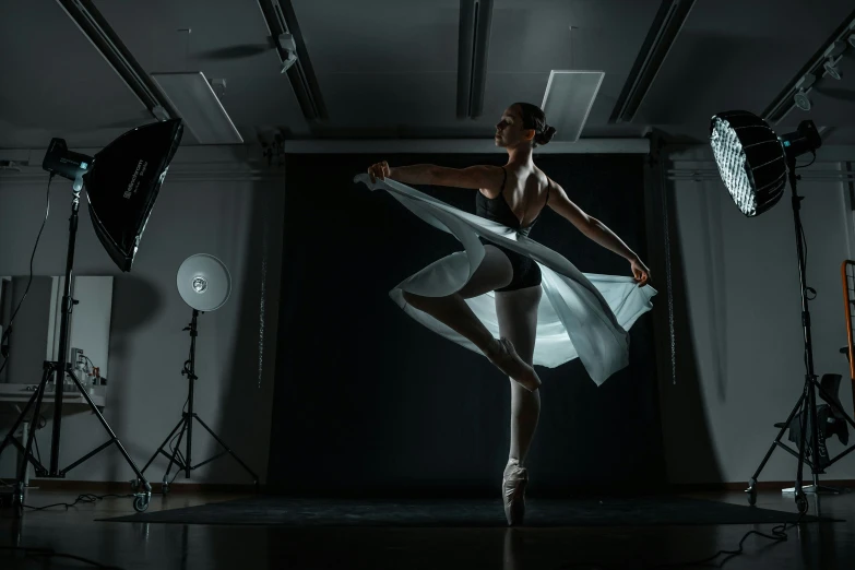 a ballerina in a black dress performing some ballet moves