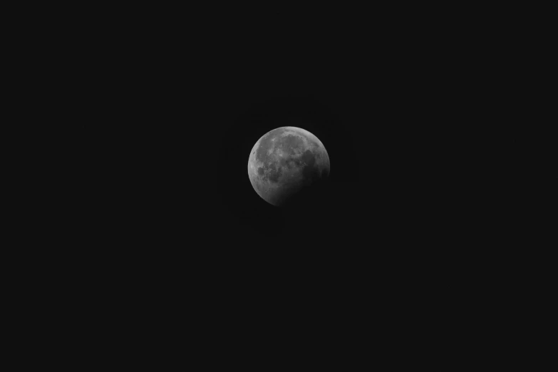 the half moon is above a building with lights on