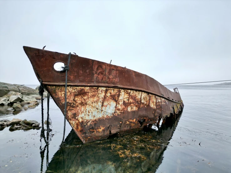 an old rusty ship sitting on top of the water