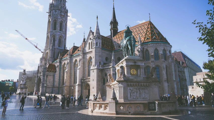 a large stone building surrounded by lots of people