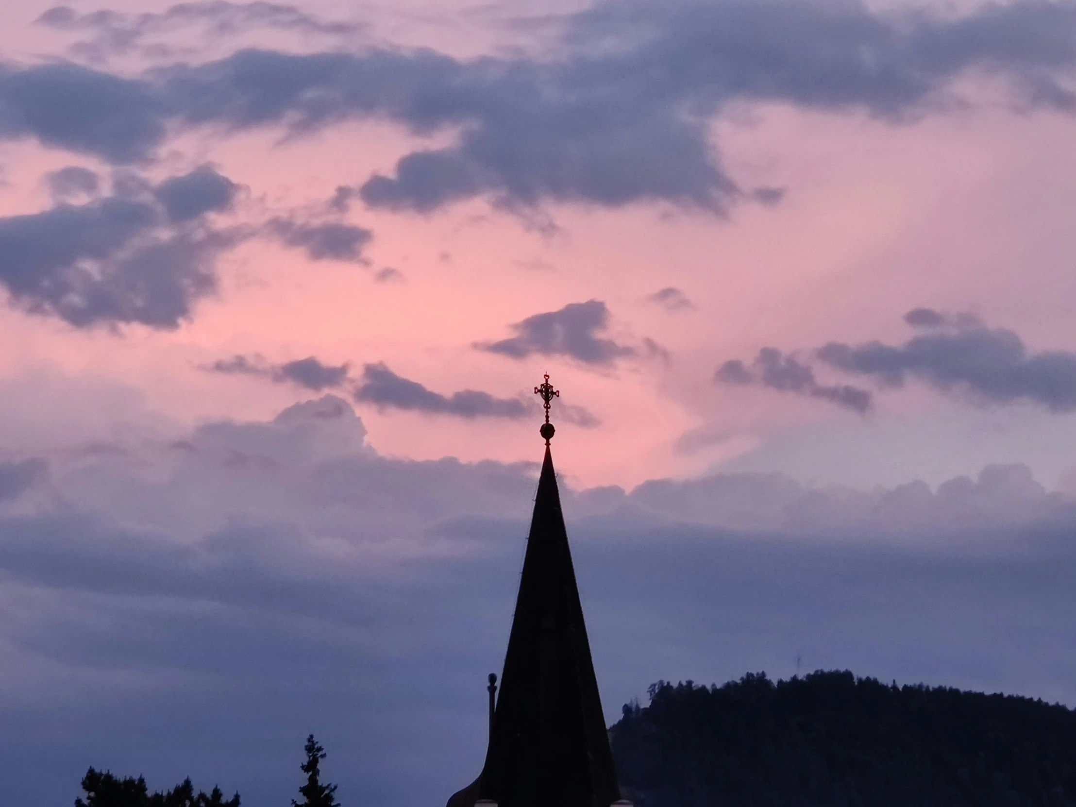 a church steeple against a pink sky