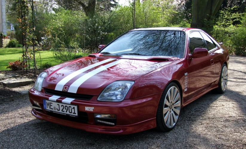 an orange sports car with white stripes parked outside