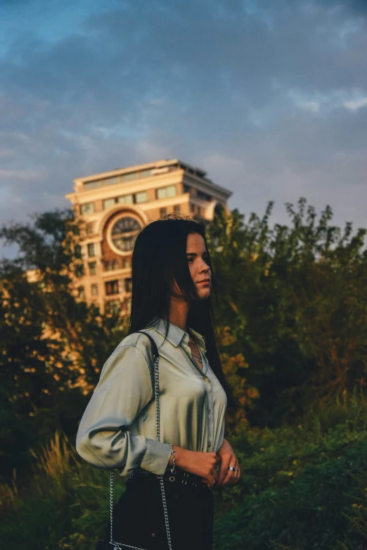 a woman is standing outside in the middle of the sunset