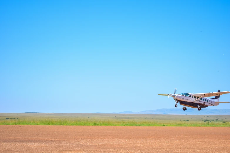 a small air plane in the air on an airport runway