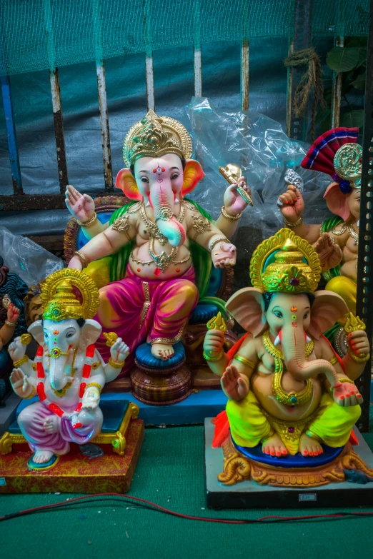 colorful indian god statues sitting on tables