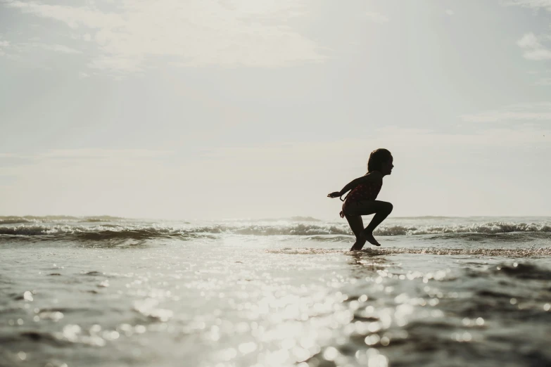 a person running in the ocean with a frisbee