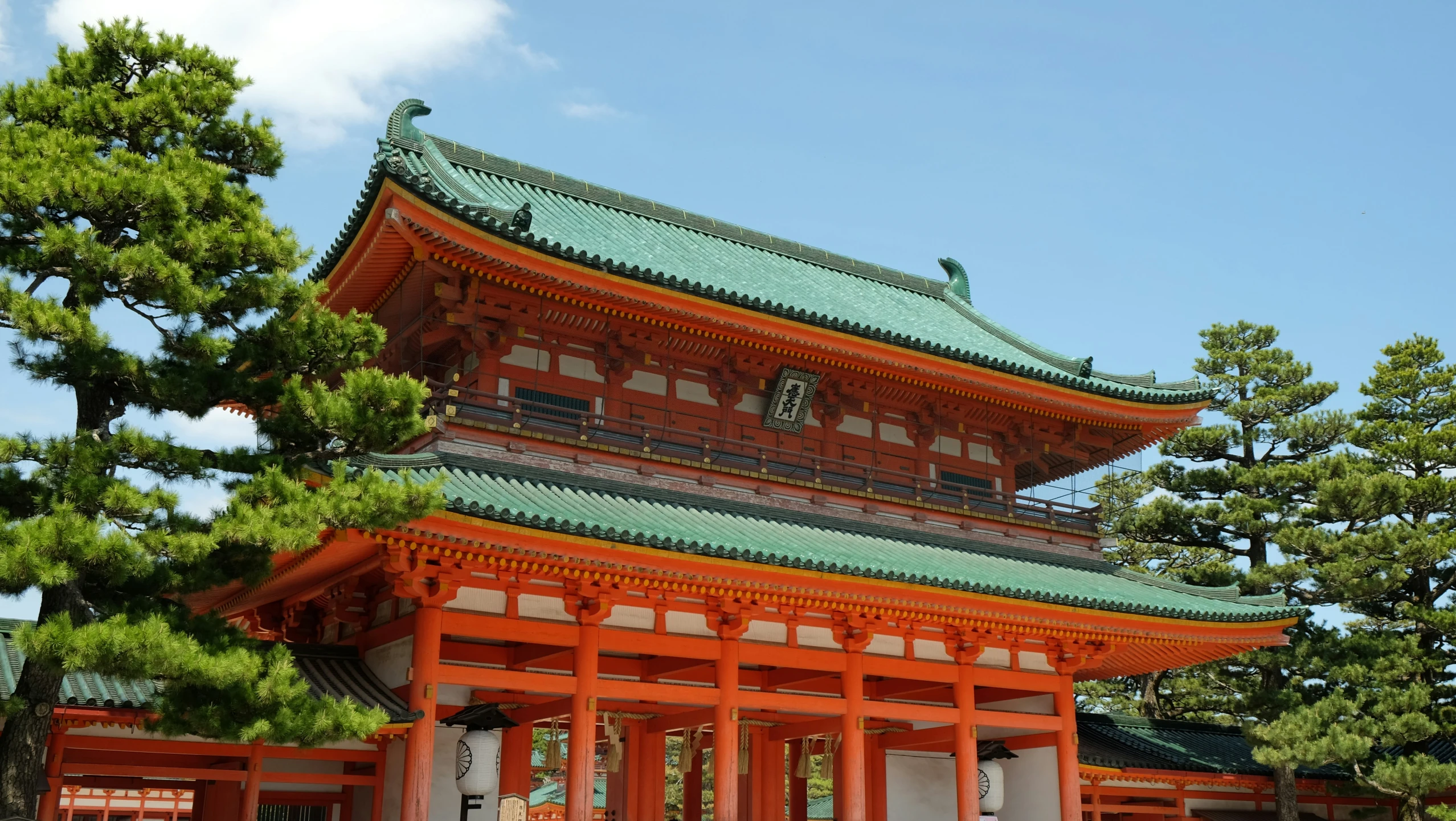 the pagoda is surrounded by trees, on the side of a road