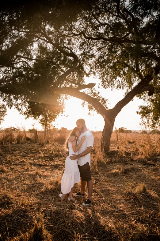 a couple sharing a tender moment together under a tree