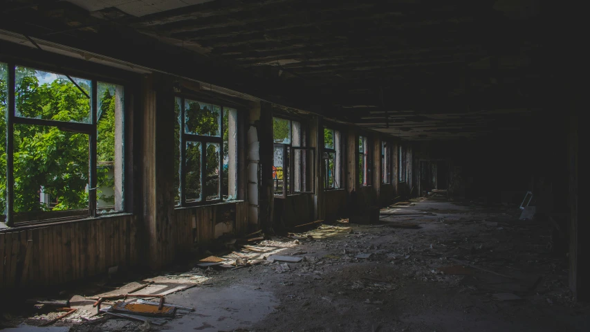 an abandoned building with broken windows in a green forest