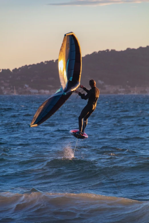 a man riding a surfboard with a parachute