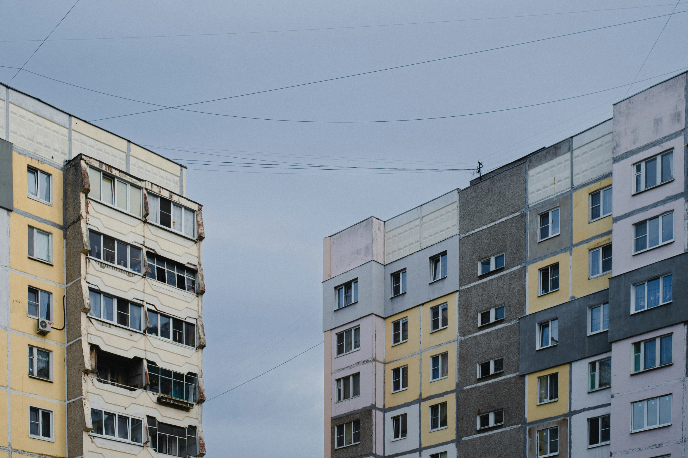 buildings and wires, in the distance are blue, yellow and grey