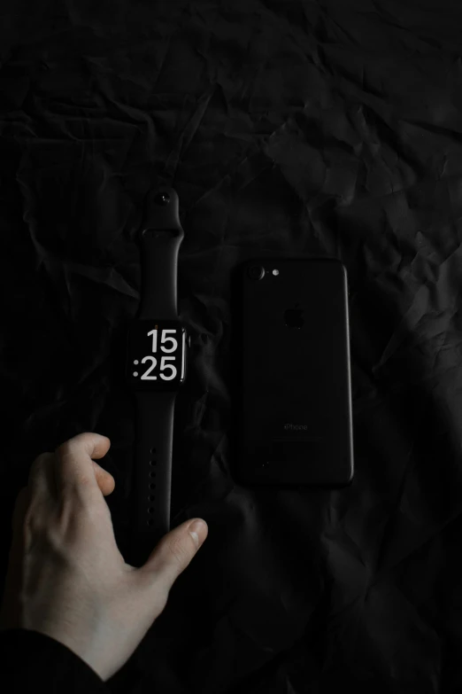 the black phone is being held in hand by someone's hand