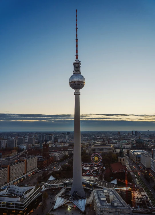 a tower with a very tall steeple stands above the city