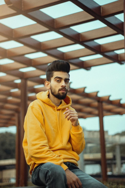 a man in yellow jacket sitting on top of a bench