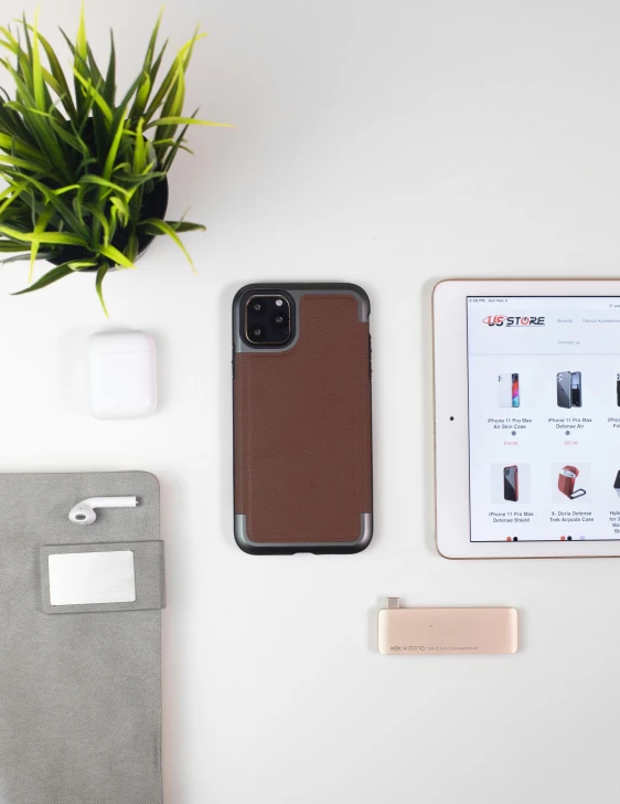 a desk with a case, pen, cellphone, and papers