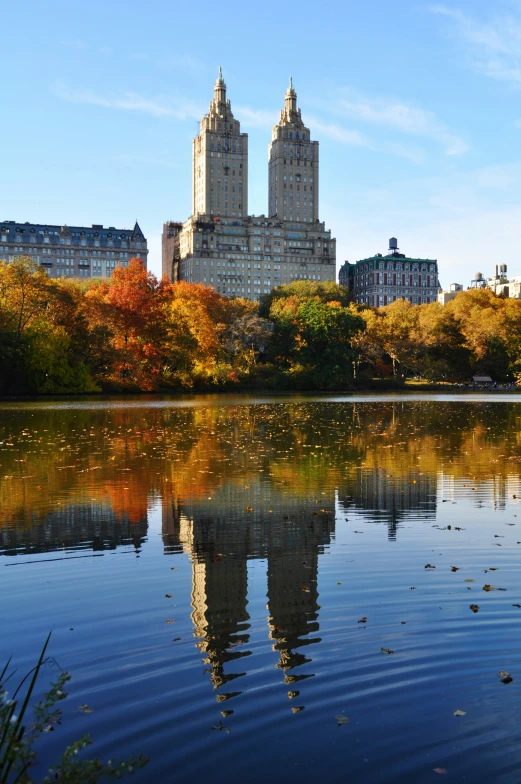 a picture of a body of water with autumn colored trees around it