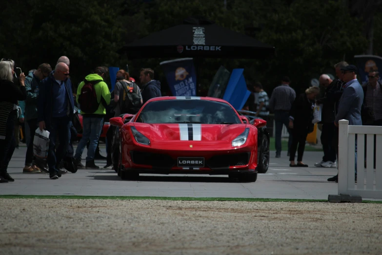 the large red sports car has a white stripe down it's side