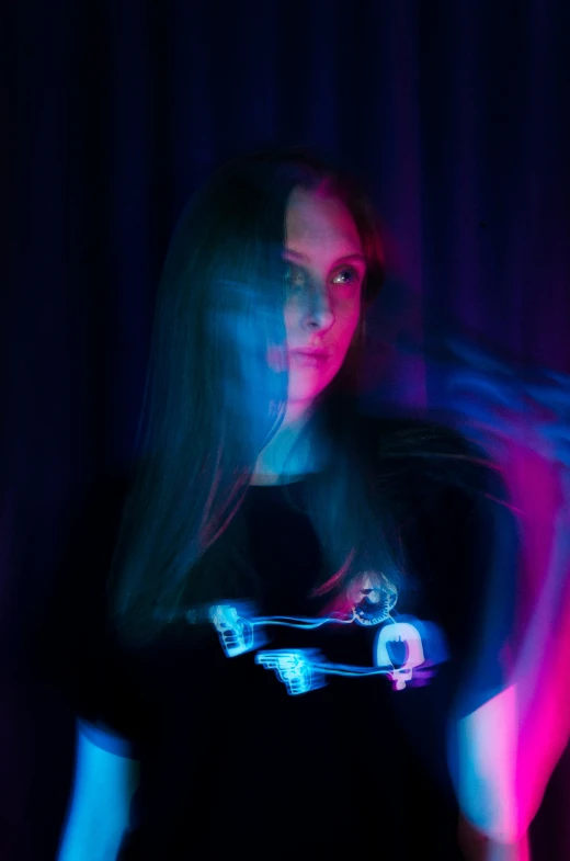 a woman standing in front of a purple and blue light