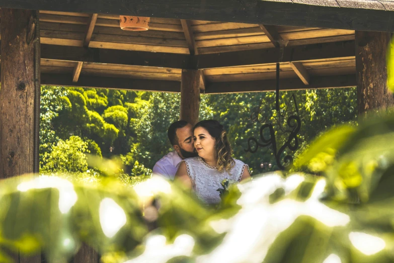 the man is holding the woman under the gazebo