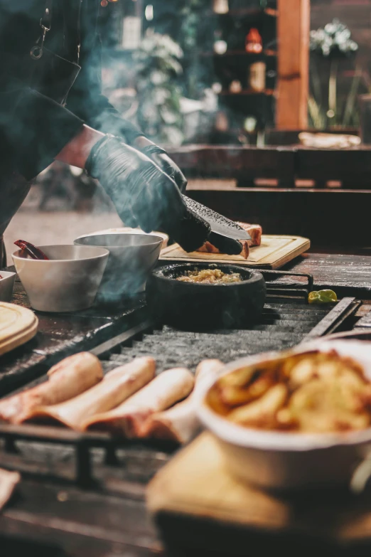 chef preparing food inside an outdoor kitchen for consumption