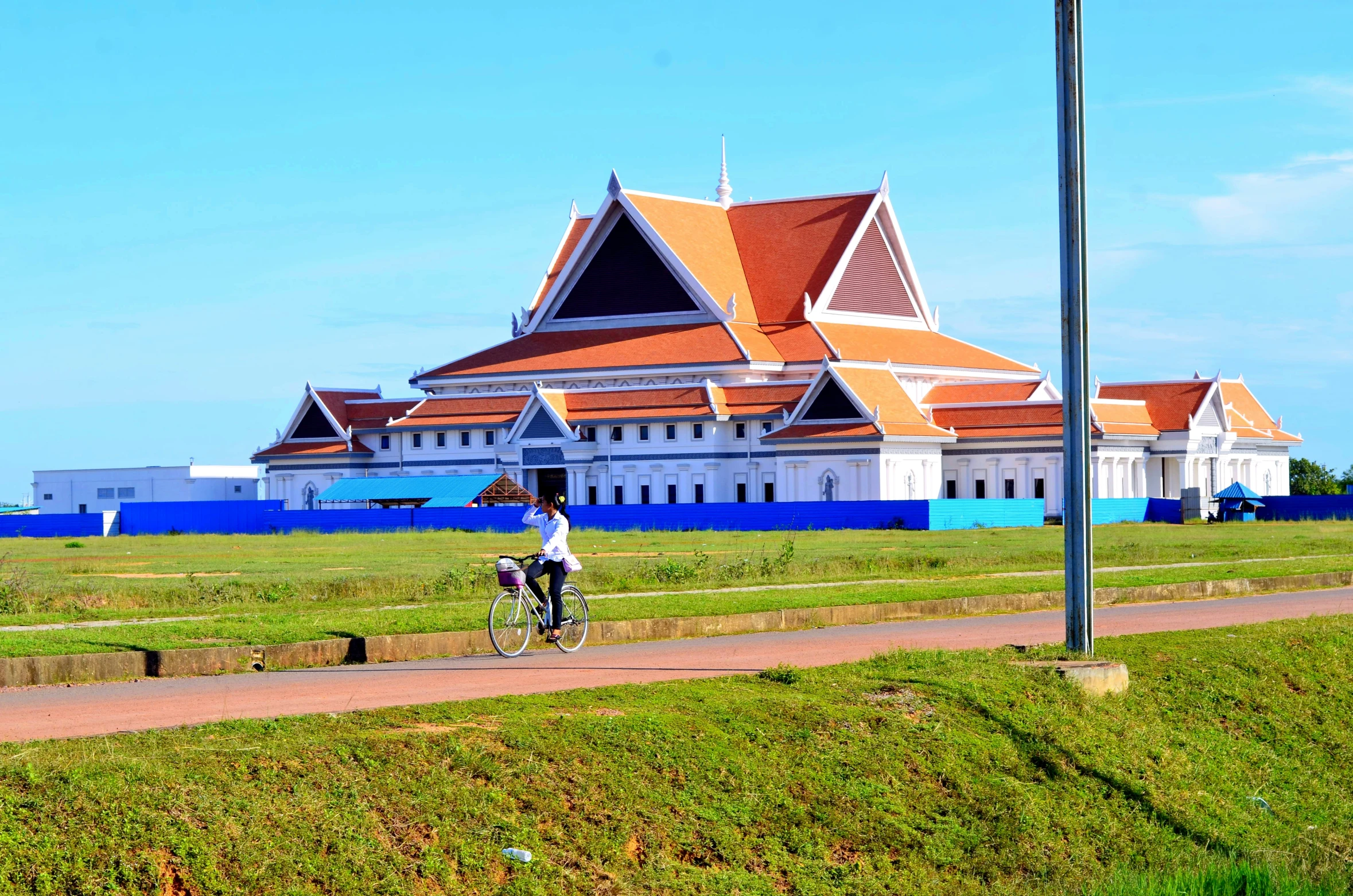 a bicyclist and a cyclist are going past some architecture in the city