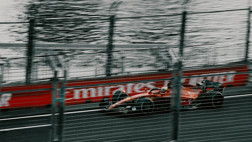 an orange race car on a wet track