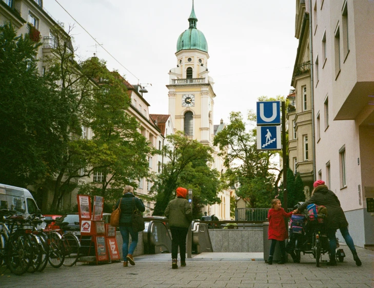 people walking with their child in a stroller, near a church