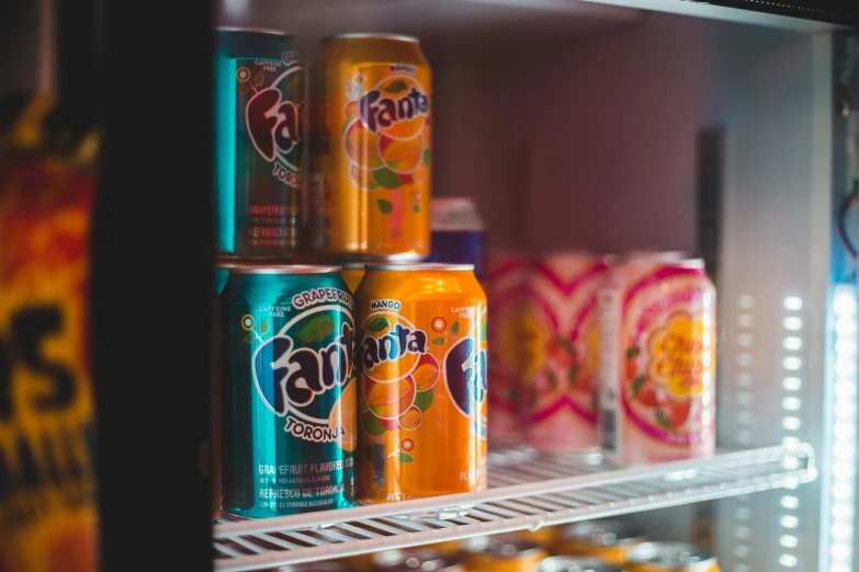 several cans of soda and soda in a glass case