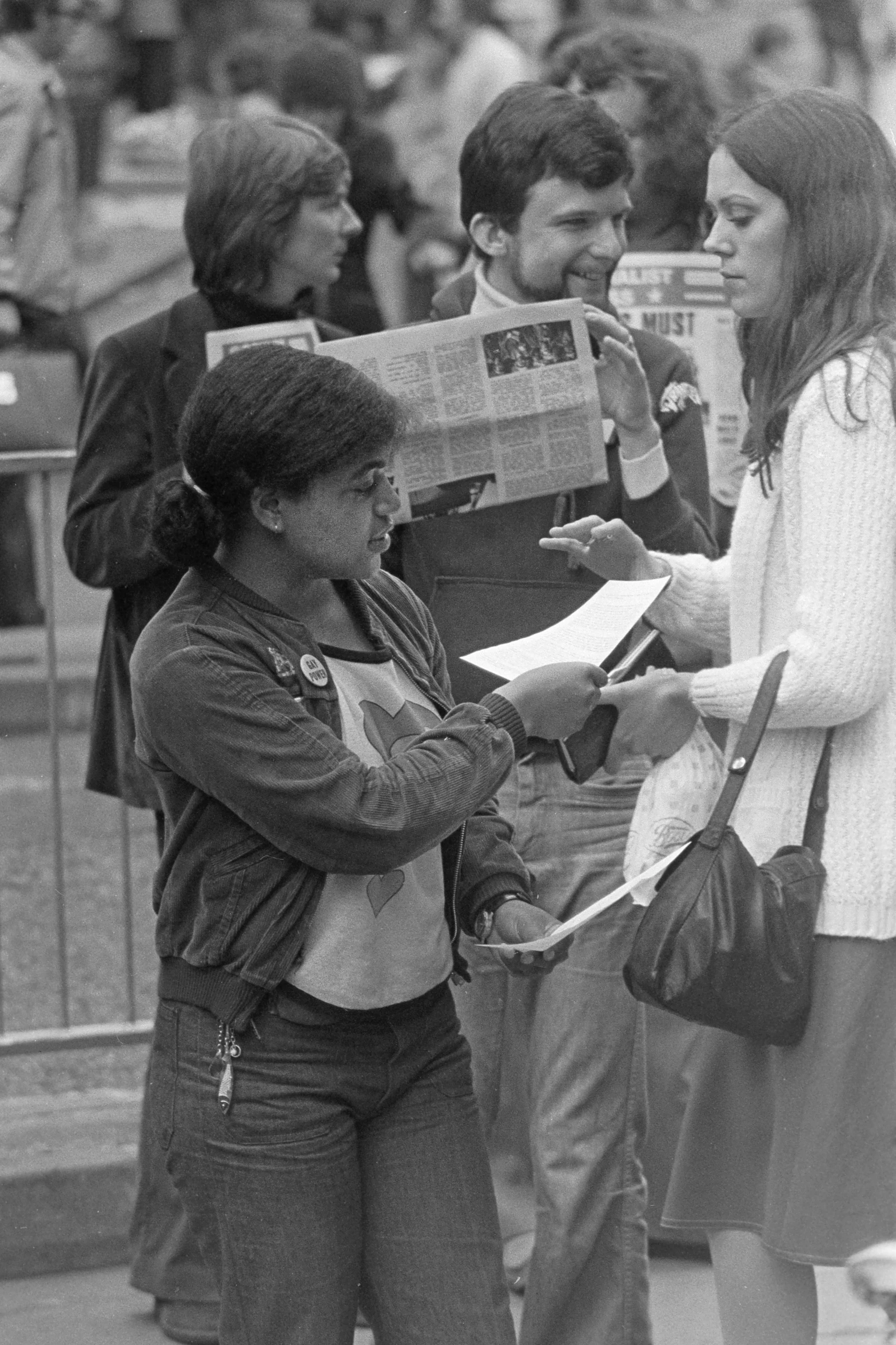 a woman reading a paper as people look on