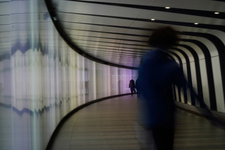 blurry pograph of people walking down an inner hallway